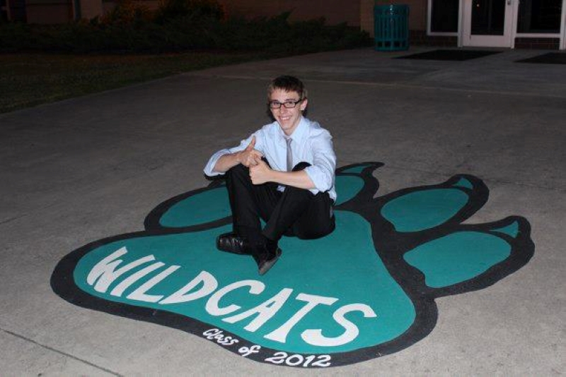 Sitting on the Wildcat footprint at high school before graduation