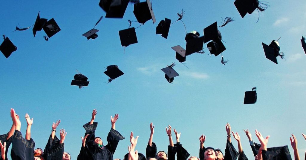 graduates throwing caps into the sky