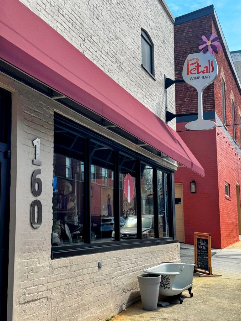 Exterior of Petals Wine Bar in Wytheville Virginia, showing restaurant sign and an old clawfoot tub.