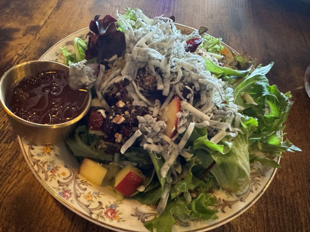 Apple and pecan salad with bleu cheese on a decorative china plate.